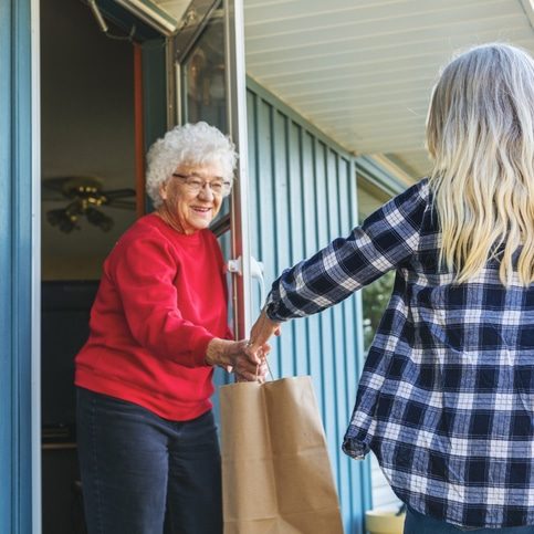 In Western Colorado Mature Adult Female Delivering Groceries to Senior Elderly Adult Female and Social Distancing Due to Infectious Virus Outbreak Pandemic Series (Shot with Canon 5DS 50.6mp photos professionally retouched - Lightroom / Photoshop - original size 5792 x 8688 downsampled as needed for clarity and select focus used for dramatic effect)