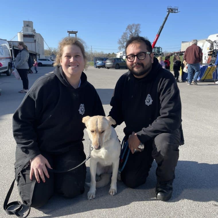 two animal control officers with a blonde dog